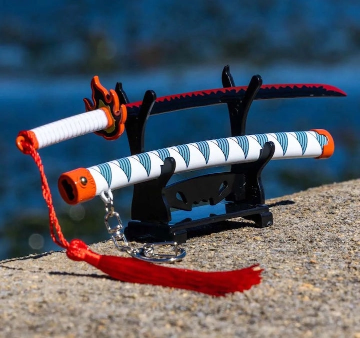 Two mini katanas resting on a small black stand