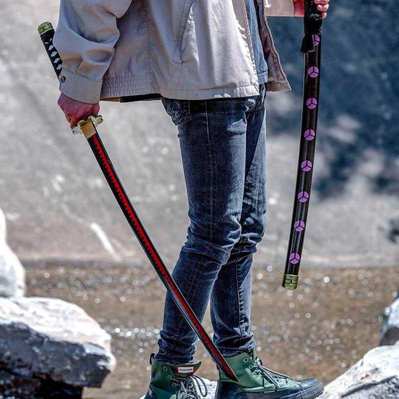 Someone standing on rocks holding two katanas at their sides